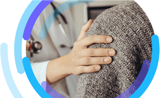 A heathcare professional's hand resting on a patient's shoulder