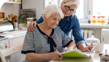 Image of two women reading together in a kitchen