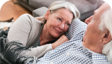 Image of woman and man sitting together on a sofa looking at each other