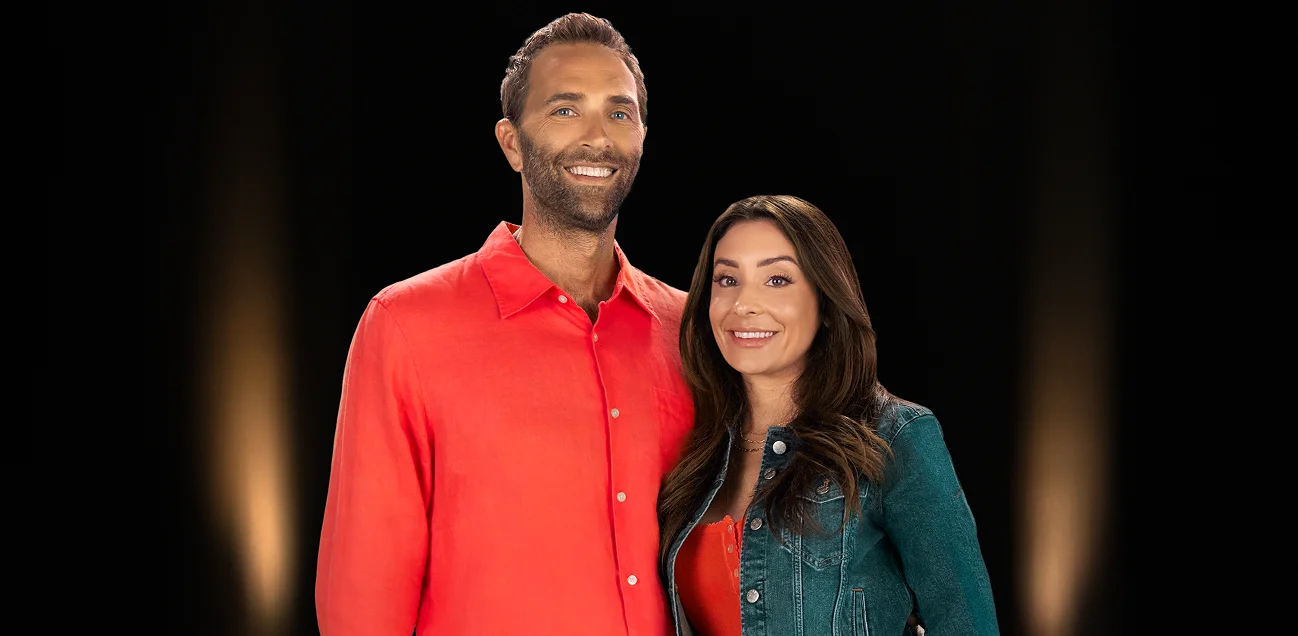 Portrait of smiling man and woman on black background.