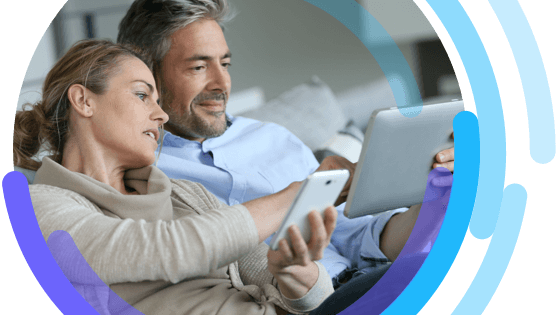 Image of man and woman sitting together and looking at a smartphone and digital tablet