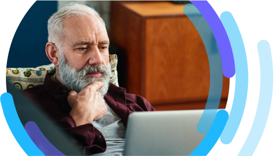 Image of man sitting in a living room looking at a laptop