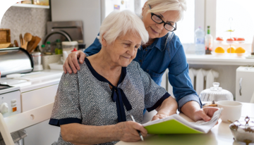 Image of two women reading together in a kitchen