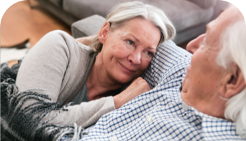 Image of woman and man sitting together on a sofa looking at each other