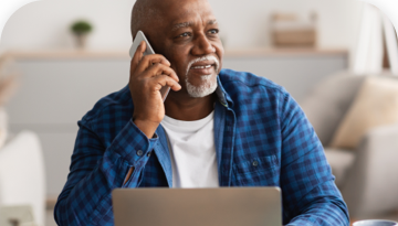 bearded man on the phone in front of a computer