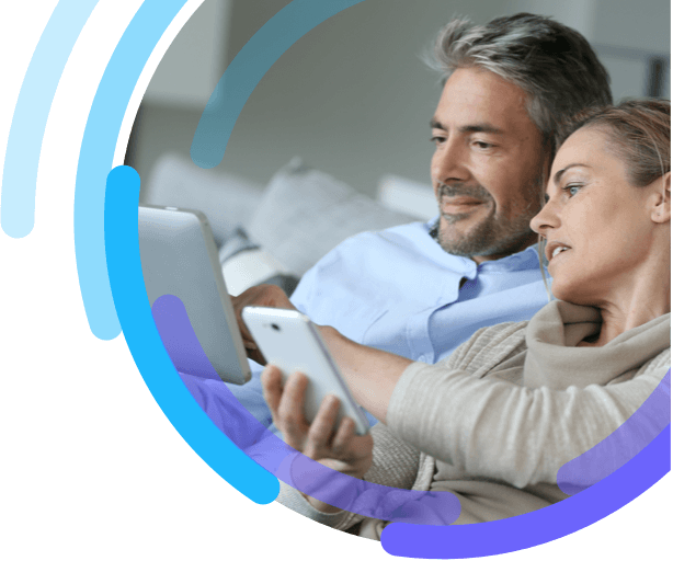 Image of man and woman sitting together and looking at a smartphone and digital tablet