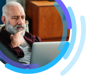 Image of man sitting in a living room looking at a laptop